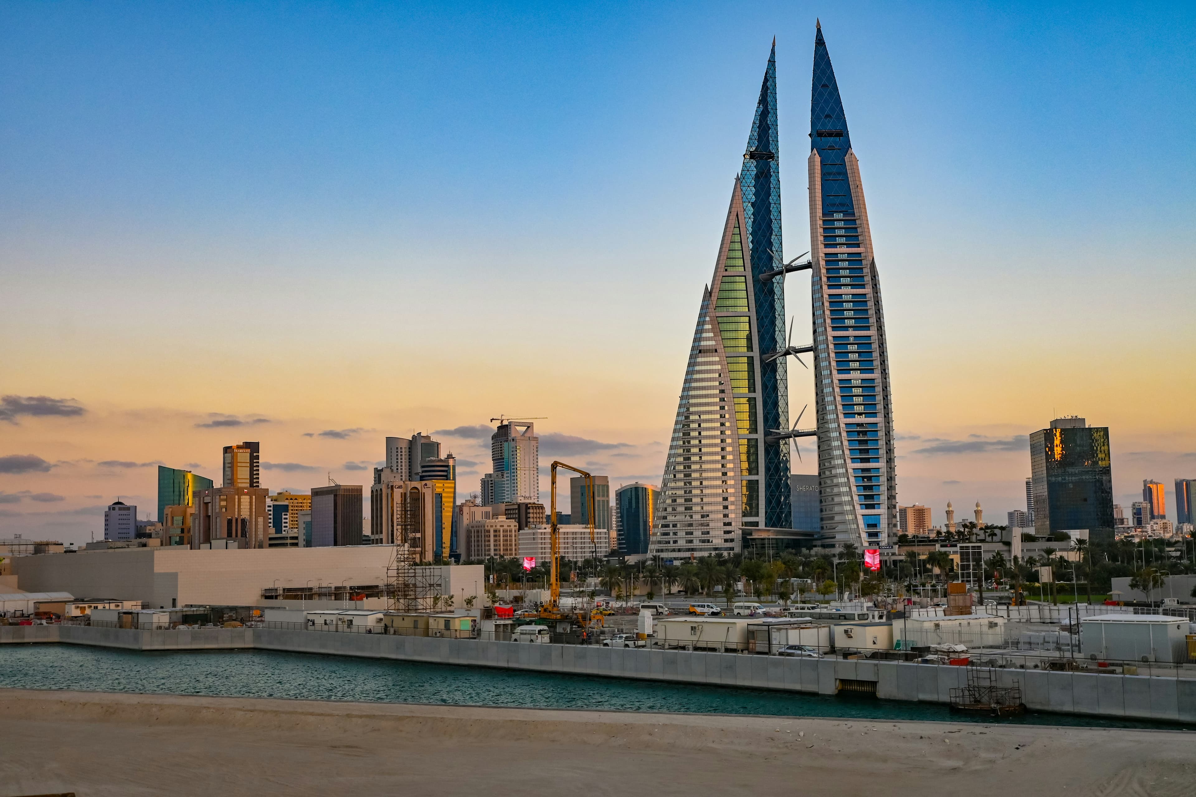 The sail-shaped twin towers of the Bahrain World Trade Center above Manama at sunrise.